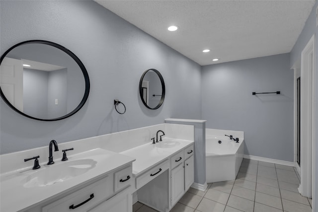 bathroom featuring a tub to relax in, tile patterned floors, vanity, and a textured ceiling