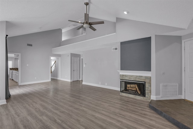 unfurnished living room with a textured ceiling, hardwood / wood-style flooring, high vaulted ceiling, and ceiling fan