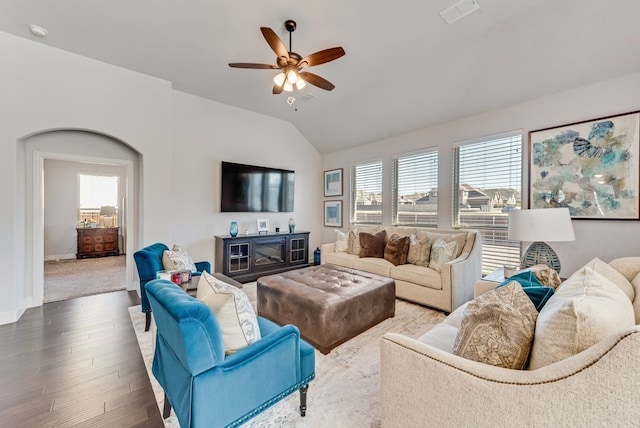 living room with ceiling fan, wood-type flooring, and vaulted ceiling