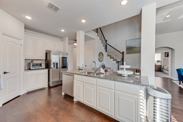 kitchen featuring white cabinetry, appliances with stainless steel finishes, sink, and light stone counters