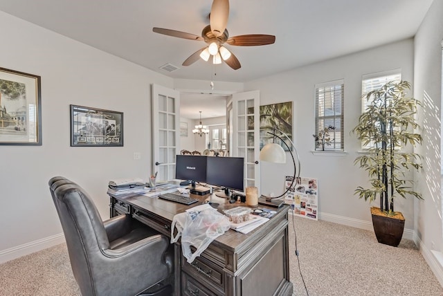 carpeted office with ceiling fan with notable chandelier