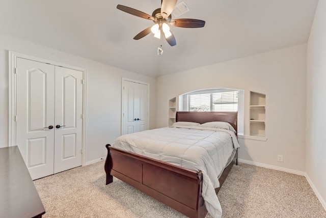 carpeted bedroom with two closets and ceiling fan