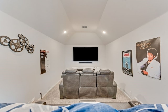 carpeted cinema room featuring vaulted ceiling