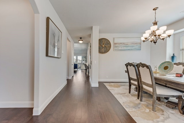 dining room with an inviting chandelier and dark hardwood / wood-style floors