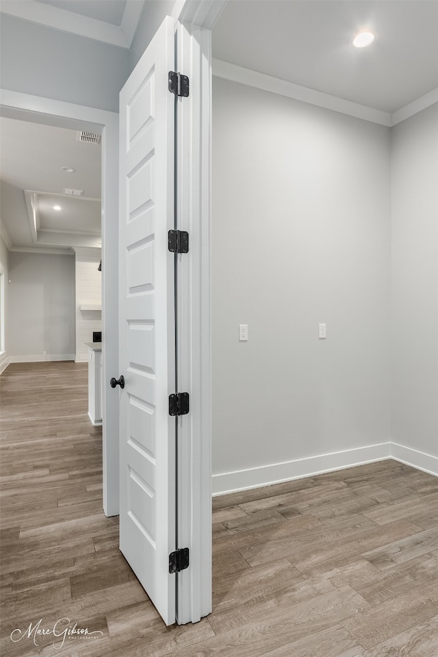 hallway featuring crown molding and light wood-type flooring