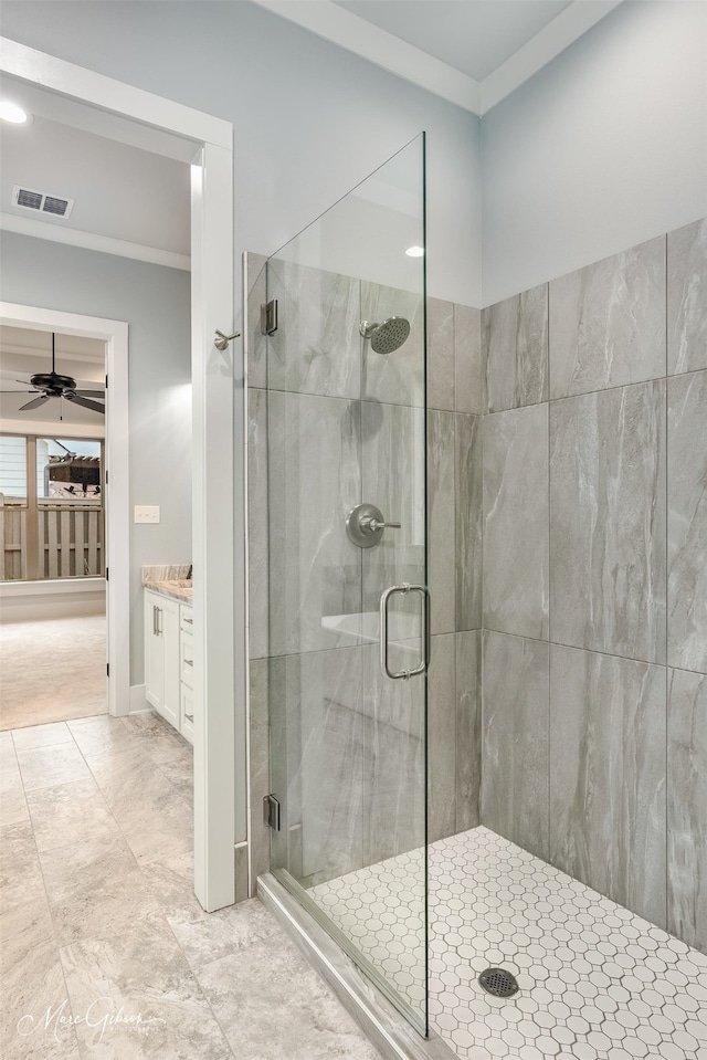 bathroom featuring a shower with door, crown molding, vanity, and ceiling fan