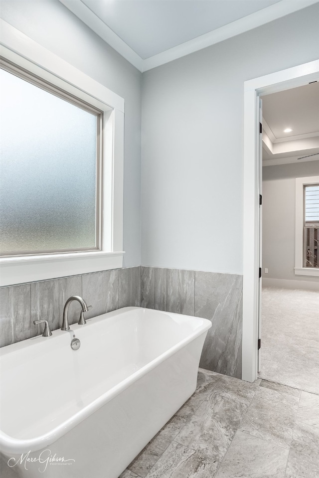 bathroom with a bathing tub and ornamental molding