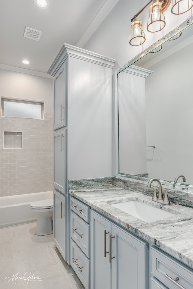 full bathroom with vanity, tiled shower / bath, and toilet