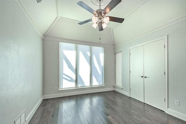 unfurnished bedroom with ceiling fan, a closet, dark hardwood / wood-style flooring, vaulted ceiling, and ornamental molding