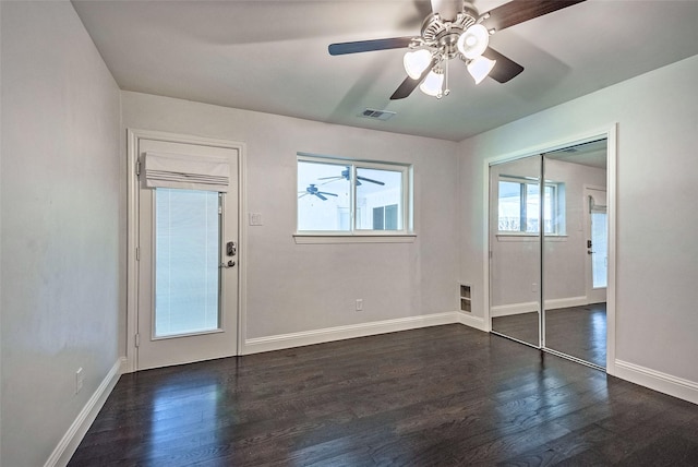 empty room featuring dark wood-type flooring and ceiling fan