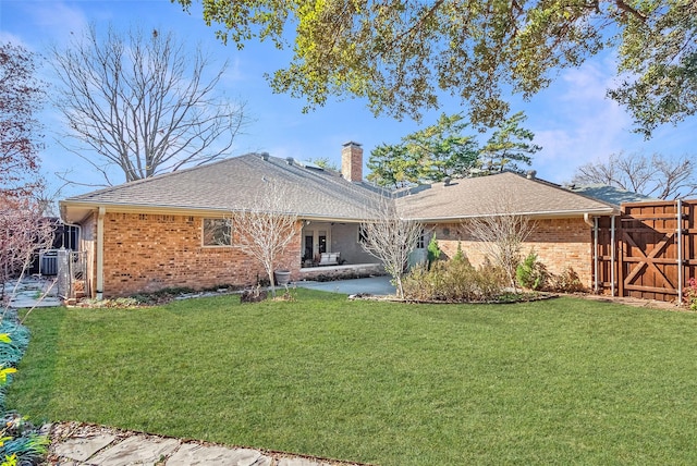 rear view of house with a patio area, a lawn, and central air condition unit