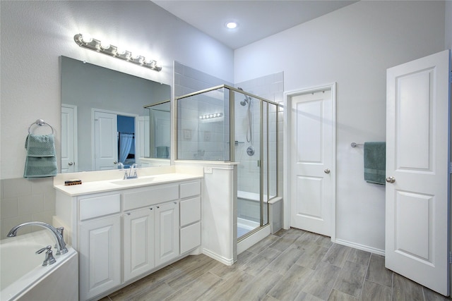 bathroom featuring hardwood / wood-style flooring, vanity, and shower with separate bathtub