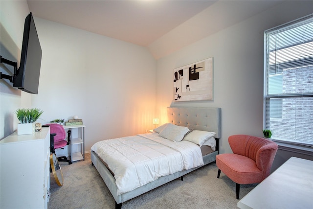 bedroom with light carpet and lofted ceiling