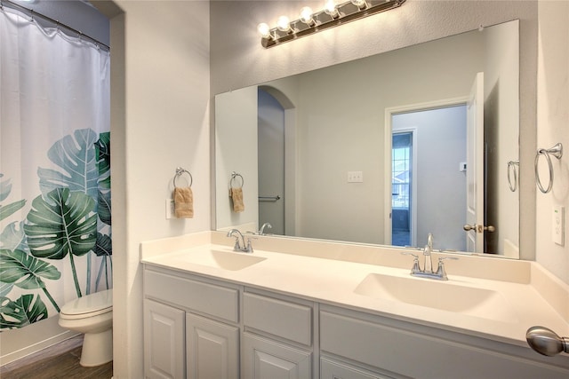 bathroom featuring hardwood / wood-style floors, vanity, a shower with shower curtain, and toilet