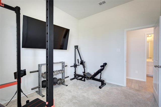 exercise room with light wood-type flooring