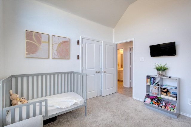 bedroom with light carpet, high vaulted ceiling, and a nursery area