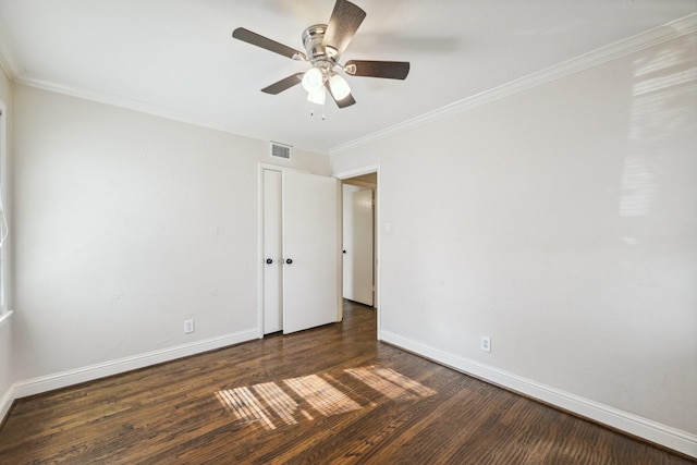 empty room with ceiling fan, dark hardwood / wood-style flooring, and crown molding