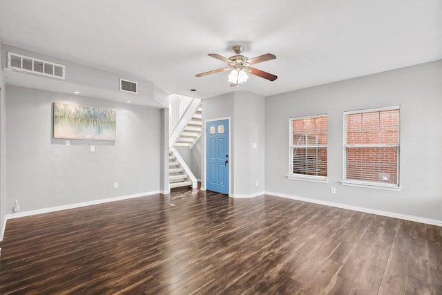 unfurnished living room featuring ceiling fan and dark wood-type flooring