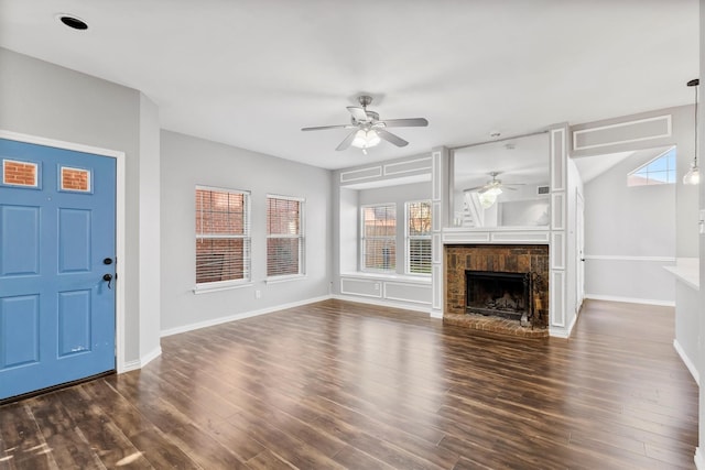 unfurnished living room featuring ceiling fan, a fireplace, and dark wood-type flooring