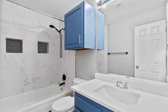 full bathroom featuring toilet, vanity, a textured ceiling, and tiled shower / bath