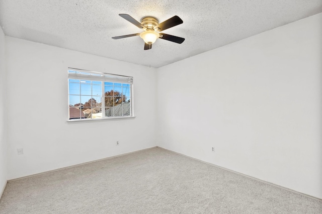 carpeted empty room featuring ceiling fan and a textured ceiling