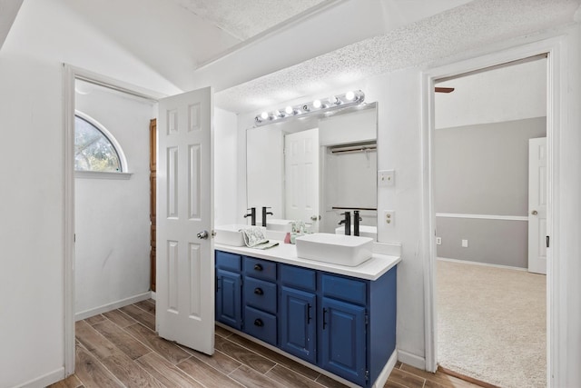 bathroom with vanity, a textured ceiling, and hardwood / wood-style flooring