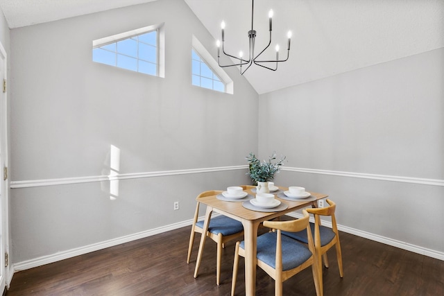 dining space featuring dark hardwood / wood-style flooring, lofted ceiling, and a notable chandelier