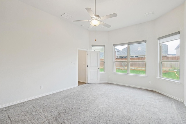 carpeted empty room with plenty of natural light and ceiling fan