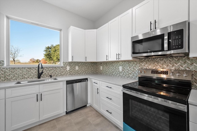 kitchen featuring white cabinetry, appliances with stainless steel finishes, sink, and backsplash