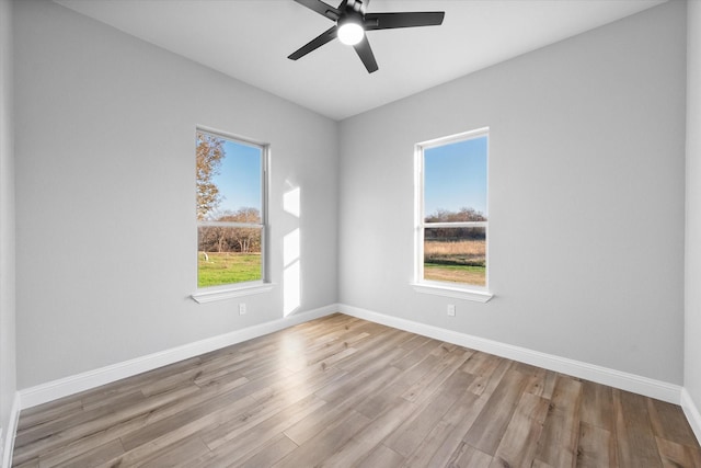 unfurnished room featuring ceiling fan, light hardwood / wood-style floors, and a healthy amount of sunlight