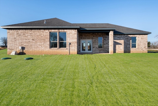 back of property featuring french doors and a lawn