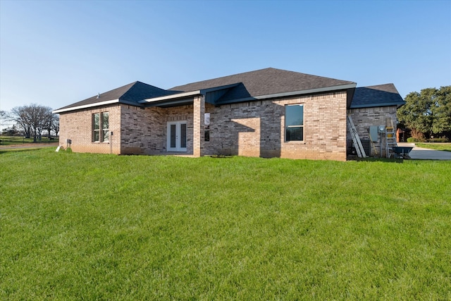 rear view of property featuring a lawn and french doors