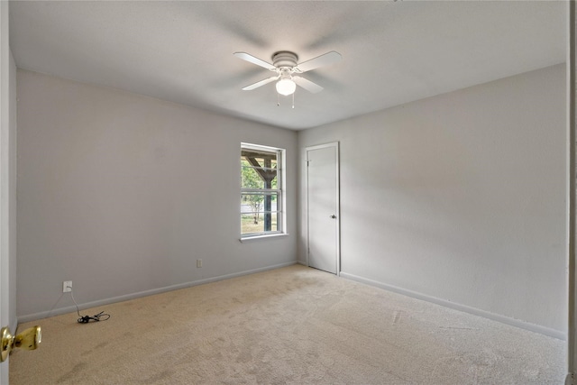 carpeted empty room featuring ceiling fan