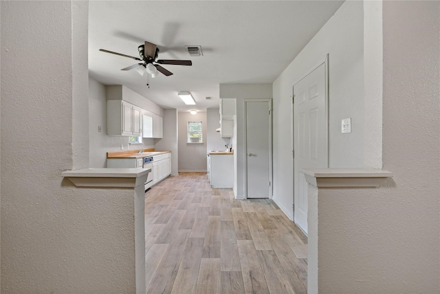 kitchen with ceiling fan, stainless steel dishwasher, light hardwood / wood-style floors, and white cabinets