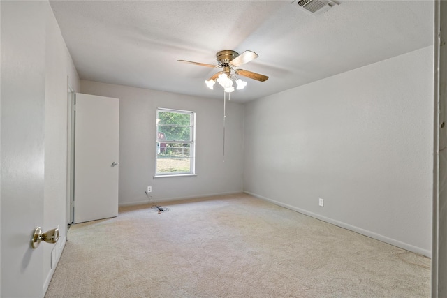 carpeted empty room with ceiling fan and a textured ceiling