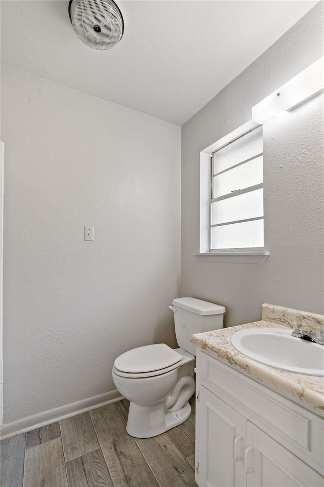 bathroom with hardwood / wood-style flooring, vanity, and toilet