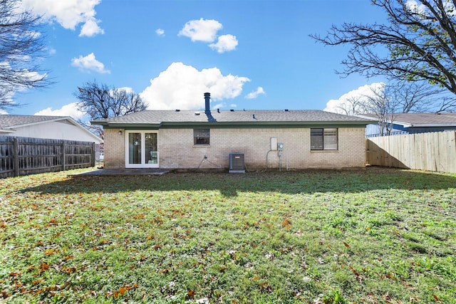 back of house featuring a lawn and central AC