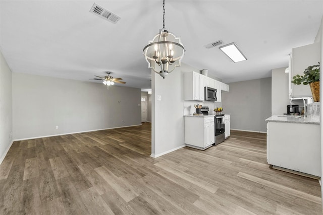 kitchen featuring ceiling fan with notable chandelier, light wood-type flooring, decorative light fixtures, white cabinetry, and stainless steel appliances