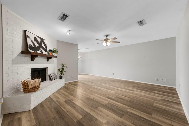 unfurnished living room featuring hardwood / wood-style floors, ceiling fan, and a fireplace