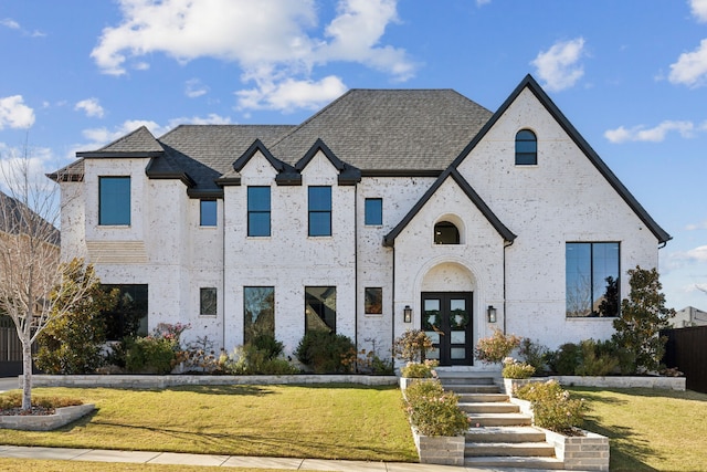 french country style house with french doors and a front lawn