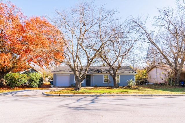 view of front of home with a front yard and a garage