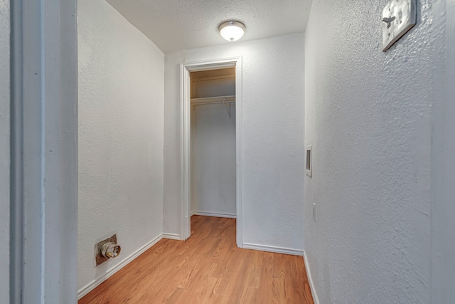 hallway featuring a textured ceiling and light wood-type flooring