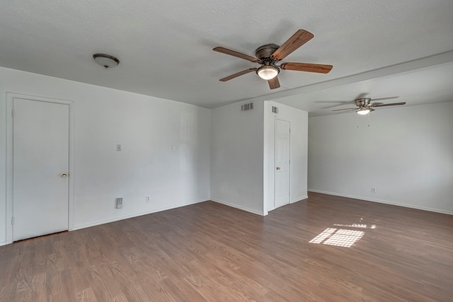 unfurnished room with dark hardwood / wood-style flooring, ceiling fan, and a textured ceiling