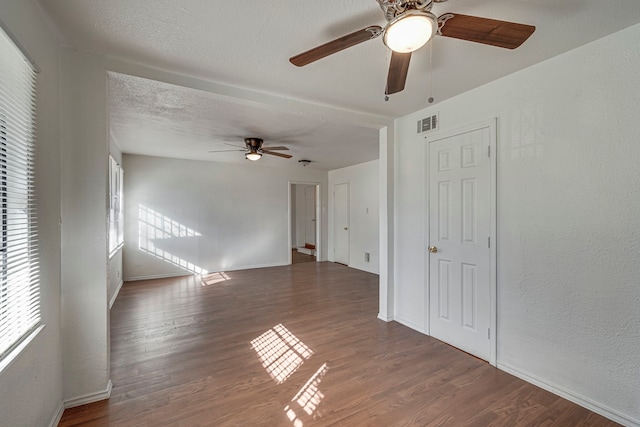 unfurnished room featuring a textured ceiling and dark hardwood / wood-style flooring