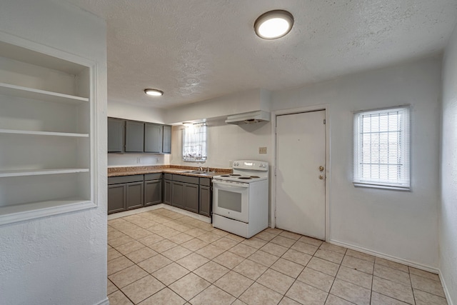 kitchen featuring light tile patterned flooring, built in features, gray cabinetry, white range with electric cooktop, and a textured ceiling