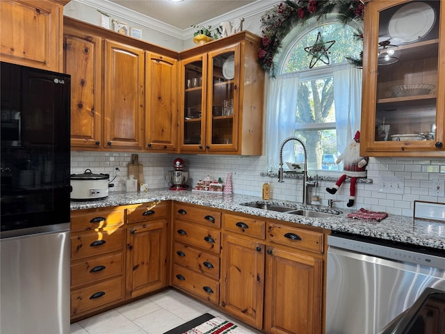 kitchen featuring light stone counters, stainless steel dishwasher, ornamental molding, sink, and light tile patterned floors