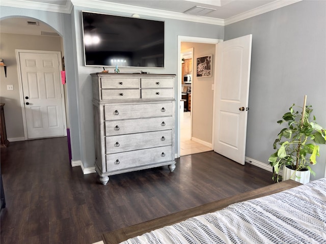 bedroom with visible vents, arched walkways, dark wood-style floors, and crown molding