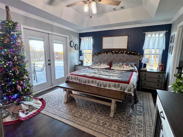 bedroom featuring french doors, ornamental molding, access to outside, a tray ceiling, and wood-type flooring