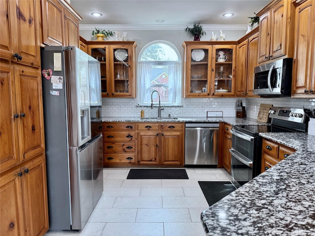 kitchen with brown cabinetry, appliances with stainless steel finishes, and a sink