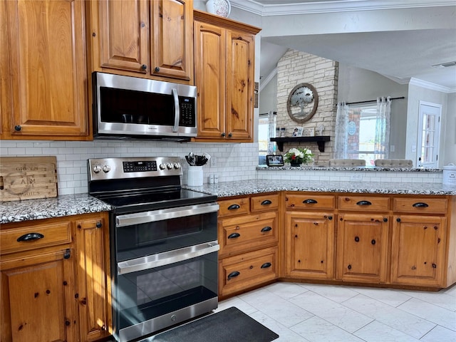 kitchen with brown cabinets, appliances with stainless steel finishes, and ornamental molding